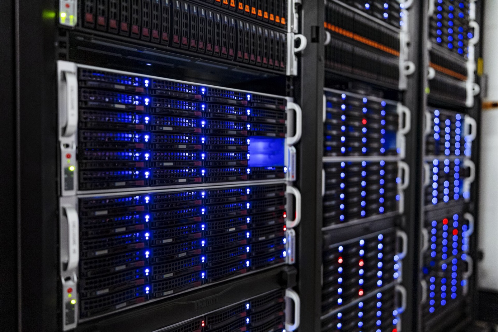 Rows of rack servers with blue status lights in a server room.
